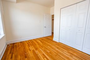 Chicago apartment for rent - A room with wooden floors and white walls.