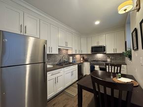 Chicago apartment for rent - A kitchen with a stainless steel refrigerator and wooden table.