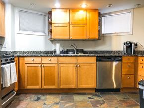 Chicago apartment for rent - A kitchen with wooden cabinets and a tiled floor.