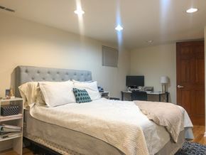 Chicago apartment for rent - A bedroom with a large bed and a television in the corner.