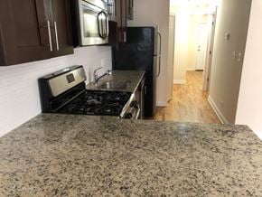 Chicago apartment for rent - a kitchen with granite countertops and a stove and a refrigerator