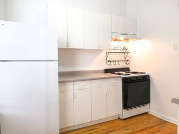 Chicago apartment for rent - A kitchen with white cabinets and a black stove top oven.