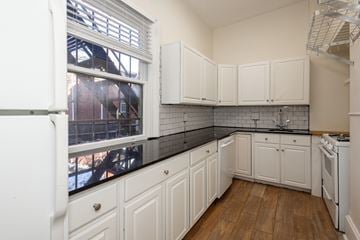 Denver apartment for rent - A kitchen with white cabinets and a black counter top.
