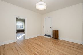 Denver apartment for rent - A room with a wooden floor and a radiator.