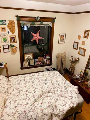 Chicago apartment for rent - A bedroom with a floral bedspread and a mirror with a starfish decoration.