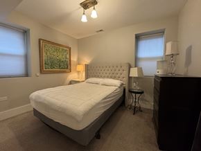 Chicago apartment for rent - A bedroom with a large bed and a painting on the wall.