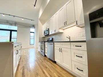 Chicago apartment for rent - A kitchen with white cabinets and wooden floors.