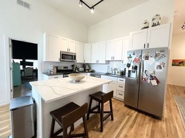 Chicago apartment for rent - A kitchen with a white counter top and a fridge with magnets on it.