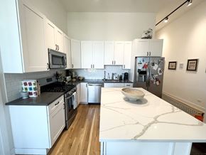 Chicago apartment for rent - A kitchen with white cabinets and a marble counter top.