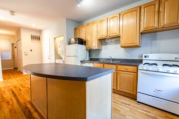 Chicago apartment for rent - A kitchen with wooden cabinets and a white stove.