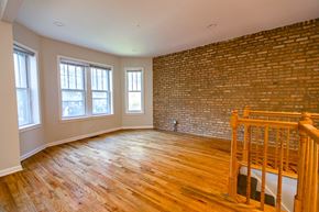 Chicago apartment for rent - A room with wooden floors and a brick wall.
