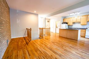 Chicago apartment for rent - A kitchen with wooden floors and a brick wall.