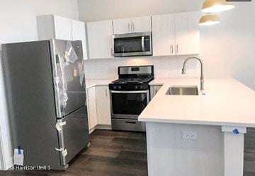 Oak Park apartment for rent - A kitchen with a white counter top and a refrigerator with a broken door.