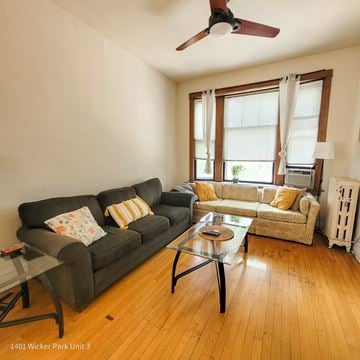 Chicago apartment for rent - A living room with a black couch and a glass coffee table.