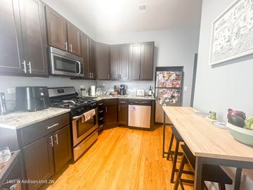 Chicago apartment for rent - A kitchen with dark wood cabinets and a white fridge.