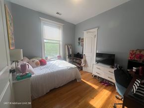 Chicago apartment for rent - A bedroom with a bed, a chair, and a TV.