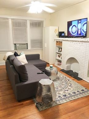 Chicago apartment for rent - A grey couch with a white pillow and a TV on the wall.