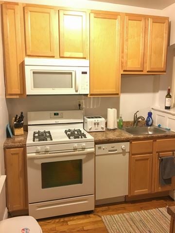 Chicago apartment for rent - A kitchen with wooden cabinets and white appliances.