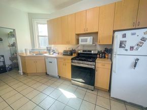 Chicago apartment for rent - A kitchen with wooden cabinets and a white refrigerator.