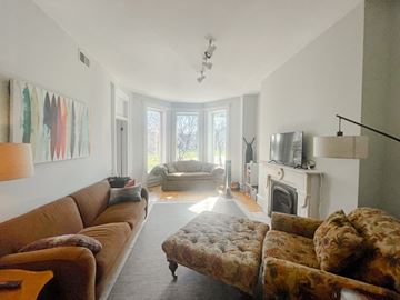 Chicago apartment for rent - A living room with a brown couch and a fireplace.