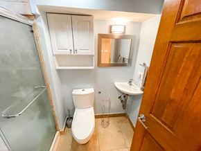 Chicago apartment for rent - A bathroom with a toilet, sink, and mirror.