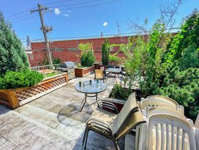 Chicago apartment for rent - A patio with a table and chairs overlooking a brick wall.