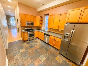 Chicago apartment for rent - A kitchen with a refrigerator, microwave, oven, and cabinets.