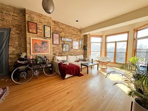 Chicago apartment for rent - A living room with a brick wall and a bicycle.