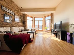 Chicago apartment for rent - A living room with a red bedspread and a white couch.