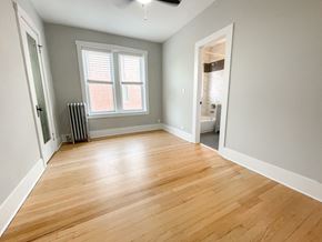 Chicago apartment for rent - A room with wooden flooring and a window with blinds.