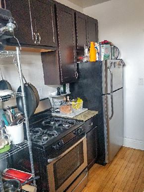 Chicago apartment for rent - A kitchen with a black stove top oven and black refrigerator.