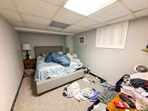 Chicago apartment for rent - A messy bedroom with a bed, dresser, and clothes scattered on the floor.
