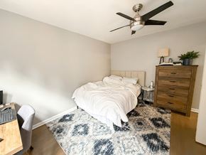 Chicago apartment for rent - A bedroom with a bed, a dresser, a ceiling fan, and a rug.