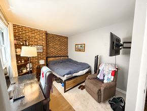 Chicago apartment for rent - A bedroom with a bed, chair, and a television.