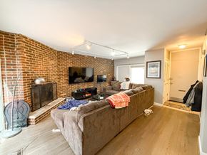 Chicago apartment for rent - A living room with a couch, a fireplace, and a television.