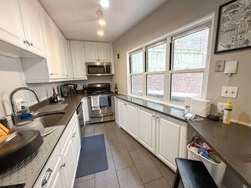 Chicago apartment for rent - A kitchen with white cabinets and a black stove top.