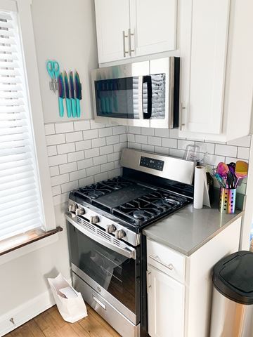 Chicago apartment for rent - A kitchen with a stove and a microwave above it.
