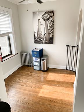Chicago apartment for rent - A room with a wooden floor and a picture of a clock on the wall.