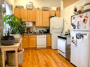 Chicago apartment for rent - A kitchen with wooden cabinets and white appliances.