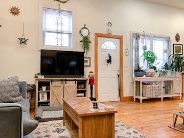 Chicago apartment for rent - A living room with a grey couch, a wooden coffee table, and a television on a cabinet.