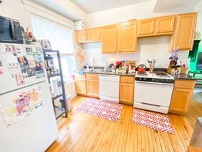 Chicago apartment for rent - A kitchen with wooden floors and white appliances.