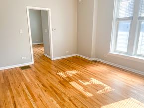 Chicago apartment for rent - A room with wooden flooring and a window letting in sunlight.