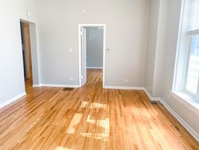 Chicago apartment for rent - A room with wooden flooring and a doorway leading to another room.