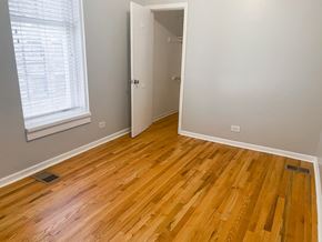 Chicago apartment for rent - A room with a wooden floor and a white door.