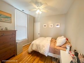 Chicago apartment for rent - A bedroom with a bed, dresser, and a ceiling fan.