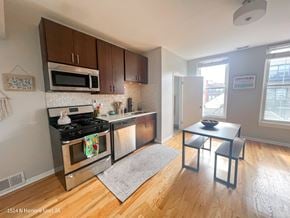 Chicago apartment for rent - A kitchen with a stove top oven and microwave.