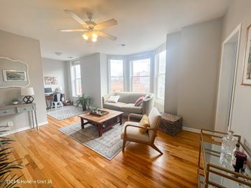 Chicago apartment for rent - A living room with a wooden floor and a ceiling fan.