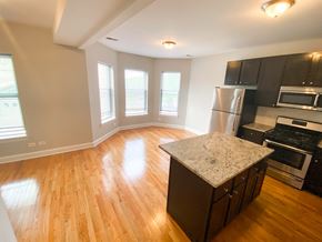 Chicago apartment for rent - an empty kitchen and living room with a hardwood floor and