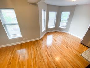 Chicago apartment for rent - an empty living room with wooden floors and windows
