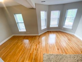 Chicago apartment for rent - an empty living room with wooden floors and three windows